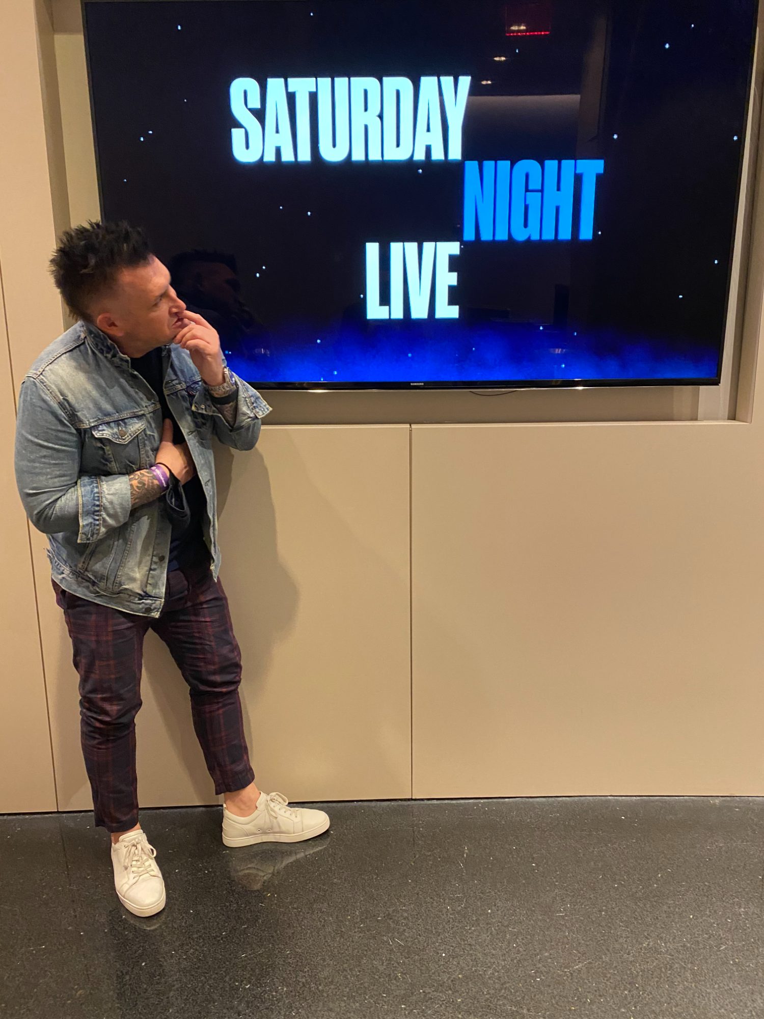 Jason Jani beside a Saturday Night Live screen