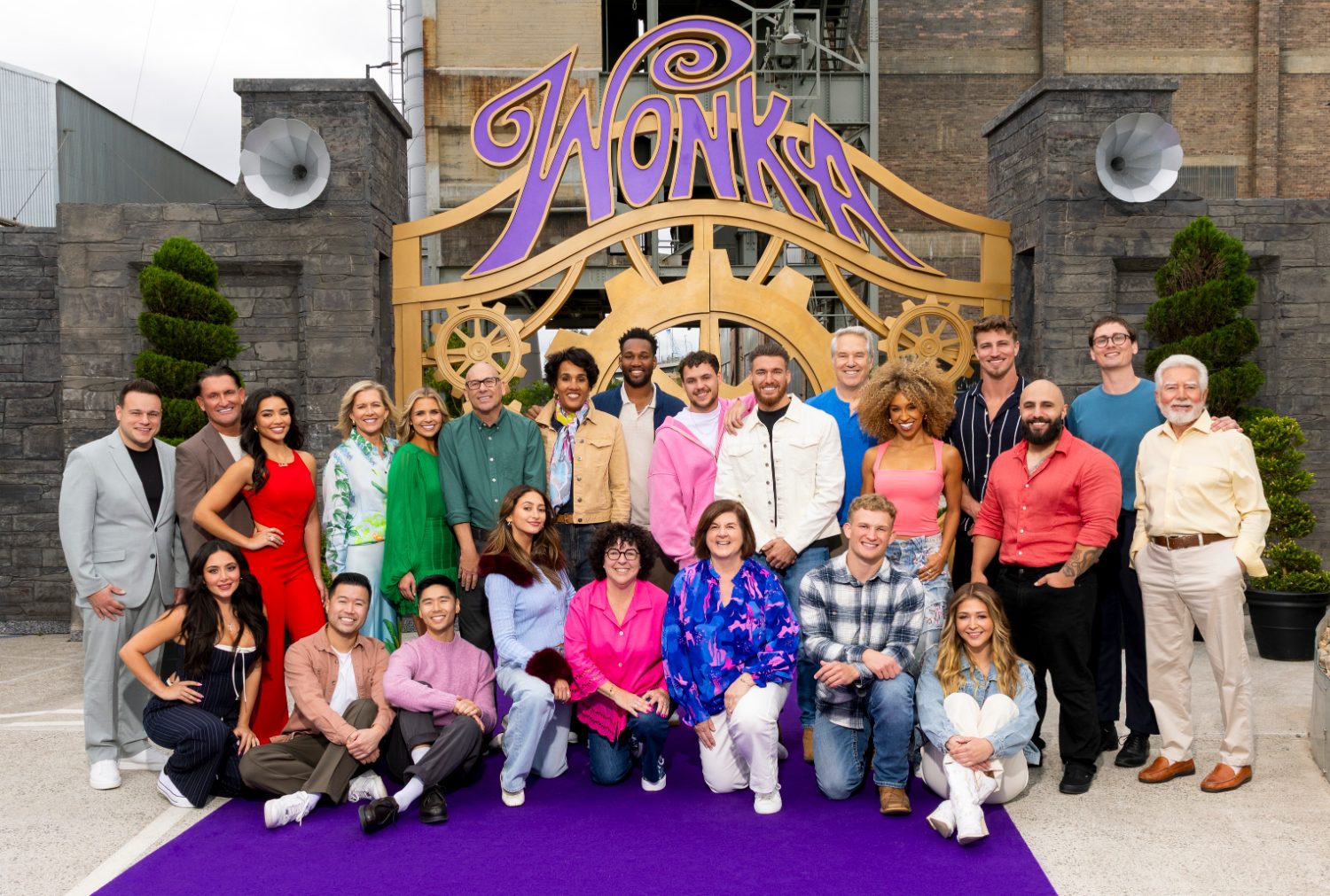 Full cast of Wonka’s The Golden Ticket at the factory gate